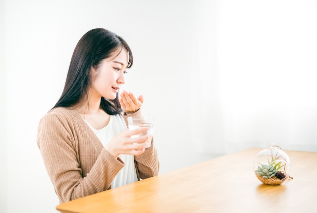 薬を飲む女性