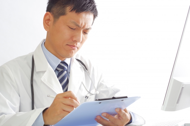 険しい顔で診察をする医師