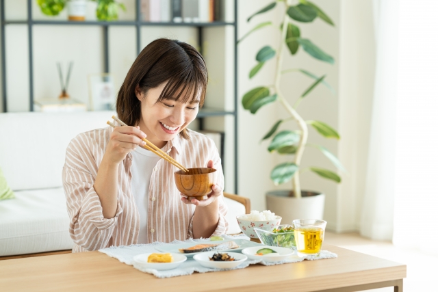 味噌汁を飲む若い女性